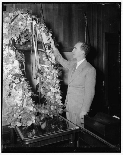 New Attorney General admires floral horseshoe, a gift of Michigan congressionals. Washington, D.C., Jan. 3. Arriving at the Department of Justice today to begin his duties as U.S. Attorney General, Frank Murphy was surprised to see this floral horseshoe draped over his desk. The token of goodluck wa