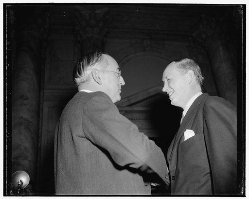 Hopkins and Chief Questioner at Senate Commerce hearing. Washington, D.C., Jan. 11. The smile on the face of Secretary of Commerce Harry Hopkins, shown talking here with Republican Senator Arthur M. Vandenberg of Michigan, soon turned to a sneer under sharp questioning by members of the Senate Comme