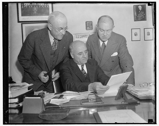 Army heads discuss plans with Military Affairs Committee. Washington, D.C., Jan. 17. General Malin Craig, Chief of Staff, U.S.A., Representative Andrew J. May, Chairman of the House Military Affairs Committee, and Secretary of War Harry Woodring looking over plans for a future Army Building Program.