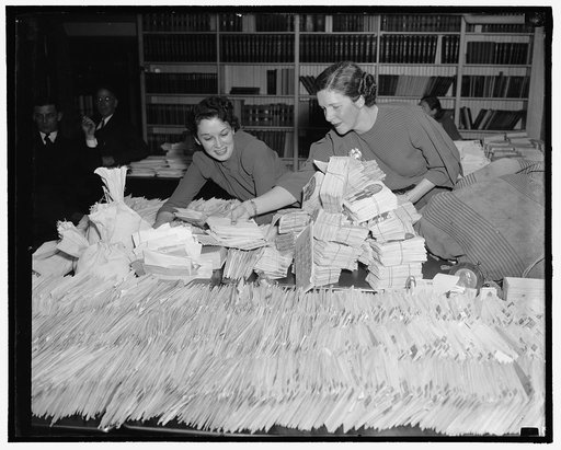 White House flooded with dimes for paralysis fight. Washington, D.C., Jan. 25. Barbara Councilor and Ethel Haberkorn, Workers in the White House Mail Room, attempting to keep up with the flood of dimes which are coming to the President's Birthday Ball Committee to add to the fund to right infantile 