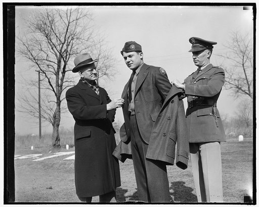 Inspects new CCC uniform. Washington, D.C., Feb. 1. Robert E. Fechner, left, Director of the Civilian Conservation Corps, inspecting the new uniform issued to members of the Corps for the first time today. The outfit consists of a two-button pleated back, sack coat of spruce green topped off with ne