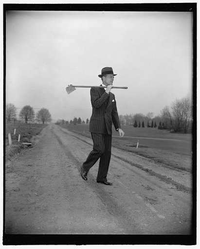 "Man with the hoe," Rep. Newt Mills. Washington, D.C., Feb. 14. Rep. Newt V. Mills, of Louisiana, who was a cotton planter in his state before coming to Washington, obliged the photographer today by demonstrating how he looks at the end of a hard day of 'choppin cotton'. One must overlook the hat an