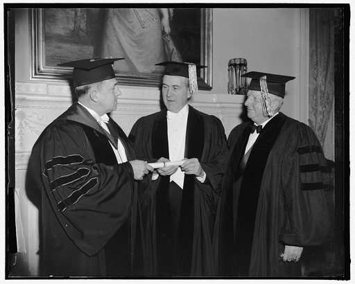 Receive honorary degrees. Washington, D.C., Feb. 23. Dr. Oswaldo Aranha, center, Brazilian Foreign Minister, receiving from Dr. Cloyd Heck Marvin, left, President of George Washington University, and honorary degree of Doctor of Laws at graduation exercises. On the right is American Ambassador from 