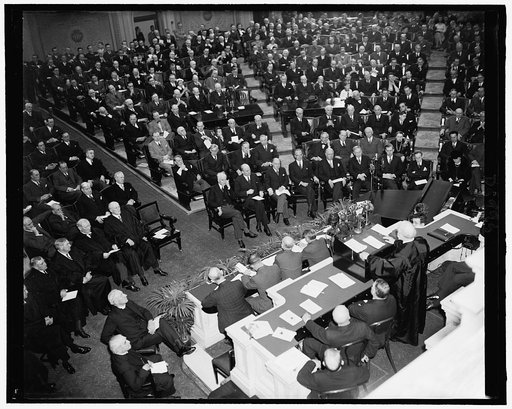 Chief Justice Hughes addressing the Joint Congressional Session on 150th Anniversary of the Congress. Seated before Hughes are Cabinet members & part of [the] Supreme Court. Left to rt. front row: Associate Supreme Court Justices Roberts, Stone, Butler, & McReynolds. Cabinet members Hull, Morgenthau
