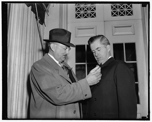 Sec. Wallace & Oscar Johnston, 3/10/39. Pinning on Shamrock for St. Patrick's Day