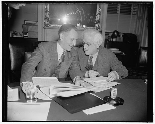 Eccles consults with statistics director during questioning at silver committee. Washington, D.C., March 23. Marriner Eccles, Chairman of the Federal Reserve Board, and E.A. Goldeneiser, Director of the Board's Division of Research and statistics, putting their heads together to find an answer durin