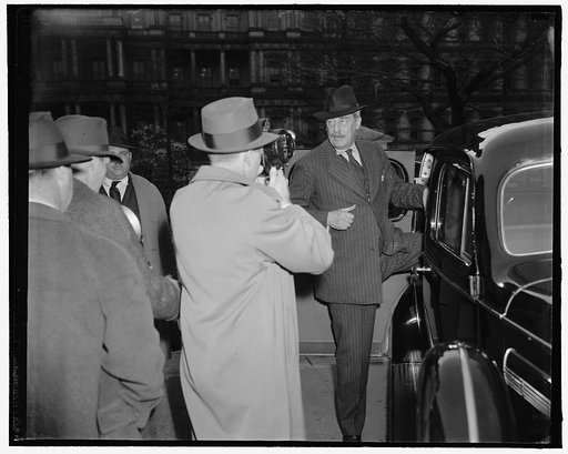 British Ambassador a White House caller. Washington, D.C., March 28. Cameramen "shoot" the British Ambassador Sir Ronald Lindsay as he leaves the White House today after a call on President Roosevelt. He refused to reveal the nature of his talk with the Chief Executive. Spanish ambassador De Los Rio