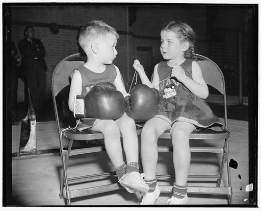 A maid sees that her knight isn't being framed. Annapolis, Md., April 15. Dorothy Wood, 5, saw to it that her small friend, 'Chuck' Andrews, 3, wasn't being framed by some of the boys who hang around [...] places. She laced on his gloves herself. The occasion was the Naval Academy's 20th Annual Juni