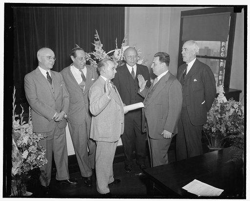 New S.E.C. Commissioner takes oath. Washington, D.C., May 18. Leon Henderson, whose nomination as a member of the Securities and Exchange Commission was recently approved by the Senate, was sworn in and assumed the post today. Left to right: Commissioner Edward C. Eicher, Commissioner Jerome Frank, 