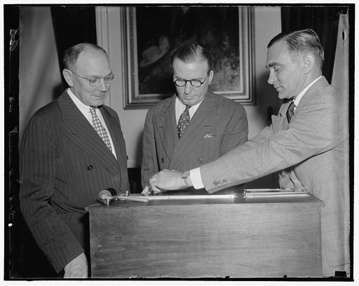 Undersecretary of Treasury is fingerprinted. Washington, D.C., May 31. In line with President Roosevelt's suggestion that all government employees be fingerprinted, John W. Hanes, Undersecretary of the Treasury, today had his prints taken by Secret Service Agent William D. Cawley, right. In the cent