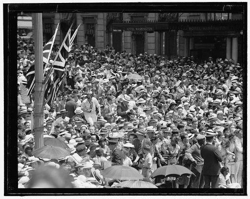 Crowd outside Hotel Washington, 15th Street and Pennsylvania Avenue, with British flags on nearby pole
