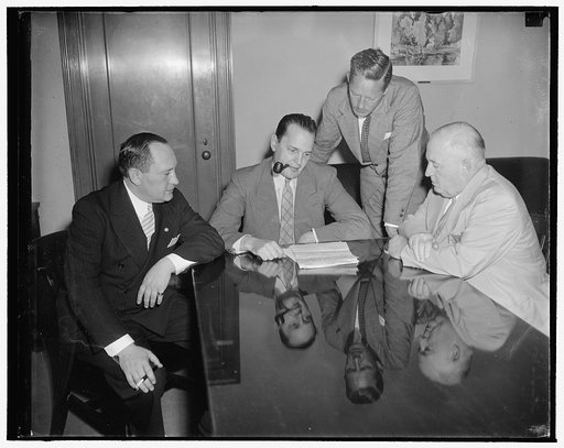 Department of Commerce. Left to right: Nathan D. Golden, Chief of Motion Picture Division of Bureau of Foreign and Domestic Commerce, Dr. Willard Thorpe, Economic Advisor to Secretary of Commerce Harry Hopkins, Ernest Tupper, Chief Statistician of Bureau of Domestic and Foreign Commerce, and Edward 