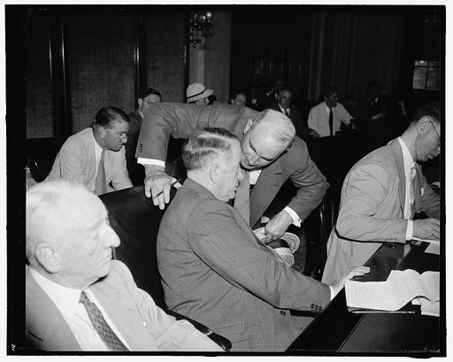 Off-the-record. Washington, D.C., July 19. Just before appearing before the Senate banking and Currency Committee today regarding the President's lending program, John J. Pelley, President of the Association of American Railroad holds a whispered conversation with Senate Majority Leader Alben W. Bar
