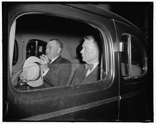 Republican Senators leave White House after conference with president. Washington, D.C., July 18. Appearing a bit wan after the night conference which the President called for tonight, Senators Warren Austin and William E. Borah were snapped in their car as the drove away from the White House steps 