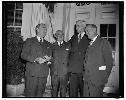 Administration agrees to allow RFC to guarantee loans to small business. Washington, D.C., July 19. Following a conference at the White House today with the above, left to right: Senator James M. Mead, New York; Senator Robert F. Wagner, New York; Jesse Jones, Federal Loan Administrator; Emil Schram