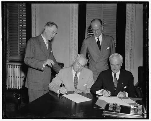 Group at desk; Sumner Welles, 2nd from right, Cordell Hull, right
