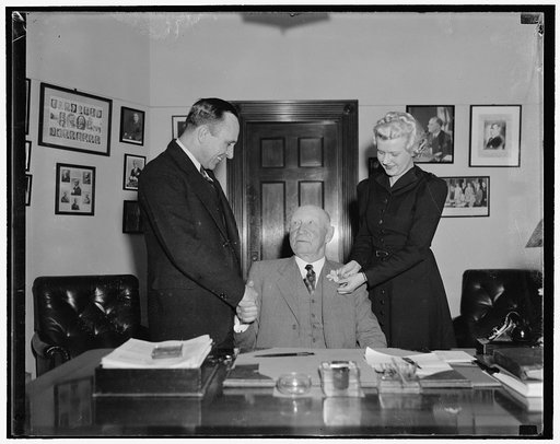 Veteran North Carolina Solon reaches 76th milestone. Washington, D.C., Nov. 7. P.W. Meeker, Secretary, congratulates Rep. Robert L. Doughton, democrat of North Carolina and Chairman of the House Ways and Means Committee, as he celebrates his 75th birthday today. Miss Jonnie Mabry, stenographer for t
