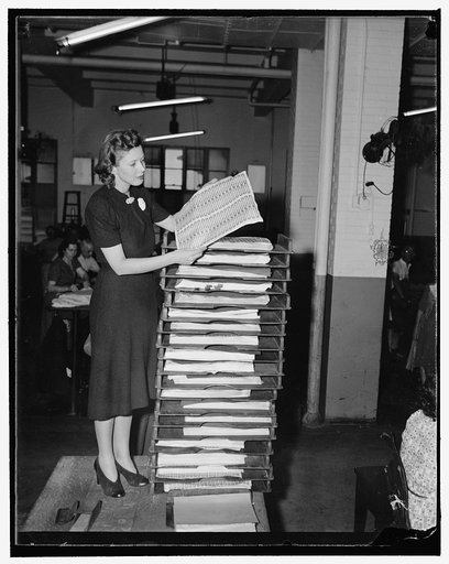 Christmas 'spirits' rush hits Bureau of Engraving and Printing. Washington, D.C., Nov. 8. In anticipation of an unusual Christmas 'spirits' rush, the U.S. Bureau of Engraving and Printing is now turning out 9,870,000 liquor stamps every day. Miss Florence Benland, Bureau employee, is pictured with t