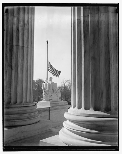 Supreme Court flag half-masted out of respect to dead jurist. Washington, D.C., Nov. 16. Scene thru the pillars of the U.S. Supreme Court Building showing the flag at half-mast out of respect to Justice Pierce Butler, who died this morning after a long illness