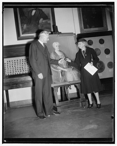 Smithsonian receives portrait of famed suffrage leader. Washington, D.C., Nov. 17. Miss Marguerite H. Welles, President of the National League of Women Voters, presenting to Dr. Alexander Wetmore, Assistant Secretary of the Smithsonian Institution, an oil painting of 80 year old Carrie Chapman Catt.