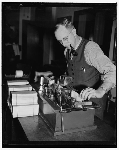 Machine signs 7,000 social security checks per hour with no writer's cramp. Washington, D.C., Dec. 14. John W. Thomas is shown here feeding social security checks into a check signing device which reels off some 7,000 checks per hour. The checks are being made at the Treasury Department's Disbursing