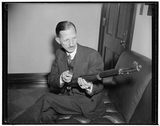 Unidentified man holding an M1 Garand Rifle and ammunition