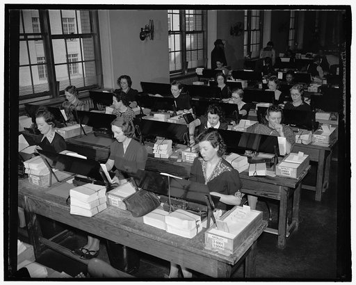 Women working with tabulating machines at long rows of desks at the US Census Bureau