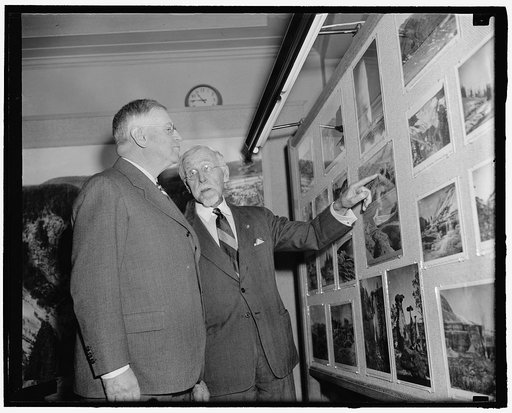 Photographer William Henry Jackson shows Secretary of the Interior, Harold Ickes an exhibit of his Western Survey photographs at the Interior Department