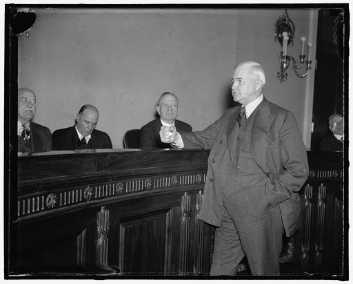 RFC Head tells House Committee 10% down payment on purchase of house is adequate. Washington, D.C., Dec. 1. RFC Chairman Jesse Jones pounds his fist to emphasize a point as he assures the House Banking and Currency Committee that the 10% down payment on the purchase of a home contemplated under Pres
