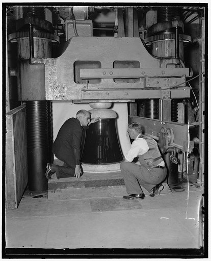 Bureau of Standards puts ruge insulator through pressure tests. Washington, D.C., Nov. 30. H.L. Whitemore, (left), chief of the Engineering Mechanics section, National Bureau of Standards, and Dr. A.H. Stand, make a final check of the huge 1600[?] pound porcelain insulator before subjecting it to 2,