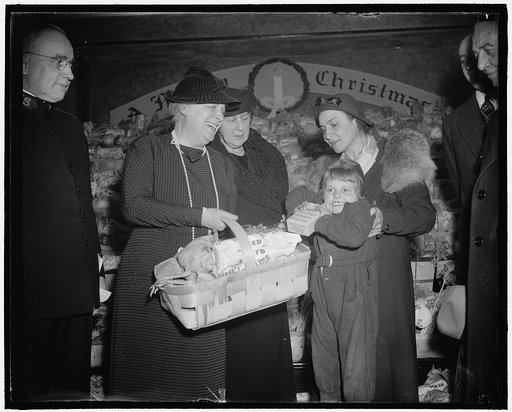 Xmas baskets for the poor. Washington, D.C., Dec. 24th. Left to right: Lady Lindsey, wife of the British Ambassador, Mrs. Cordell Hull, wife of the Sec. of State, and Mrs. John Glisson, holding her daughter Leis, 5 years old. Lady Lindsey presented the the baskets to the poor at the Salvation Army t