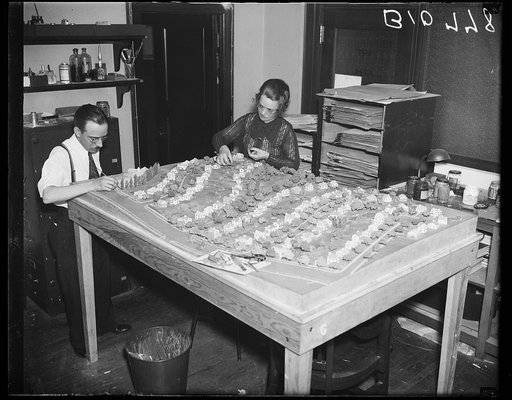 Man and woman creating model of streets with houses