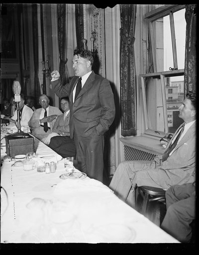 Blasts New Deal, Washington, D.C., August 7. Photo shows one of the chief speakers of the old Huey Long movement as he addressed the members of the press at the pre club in Washington. He blasted the "New Deal" in no uncertain terms. Photo shows the Rev. Gerald L.K. Smith in action front of the news