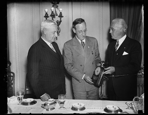 Testimonial gift., Washington, D.C. Oct. 12. John A. Remon, president of the President's cup Regatto, vice president with a testimonial gift, a beautiful electric clock topped by a model gold speedboat, by Harry P. Somerville, Executive Secretary of the Regatta, at a luncheon today in honor of the o
