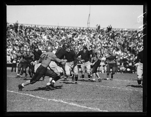 Annapolis, MD, Sept. 25. Player, Navy back, is stopped in his tracks as he intercepts a forward pass in the game today as Navy trimmed William & Mary 18-6 to open the 1936 football season here
