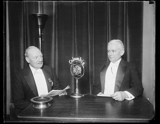 Men seated at Columbia microphone; Hiram Bingham, right