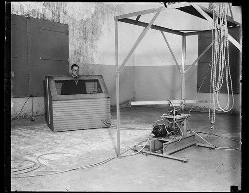 Uncle Sam seeking way to improve theaters for talkies. How to improve theaters for talking motion pictures is a problem now being tackled by the Bureau of Standards. V.L. Chrisler of the Sound Section, who looks like he is imprisoned in stocks, is really studying the "echo effect" in this room and h