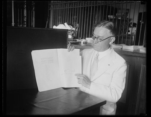 Man holding book signed by S. Gaselee