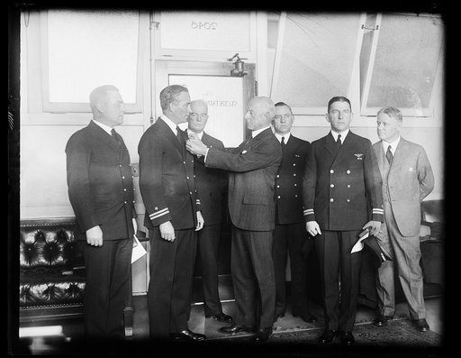 Naval flyers receive decorations. Secretary of the Navy Adams presents Distinguished Flying Cross to four noted Navy flyers. Left to right: Chief Aviation Pilot, Harold I. June, who was decorated for his service with the Byrd Antarctic Expedition: Lieut. Richard F. Whitehead, receiving the decoratio
