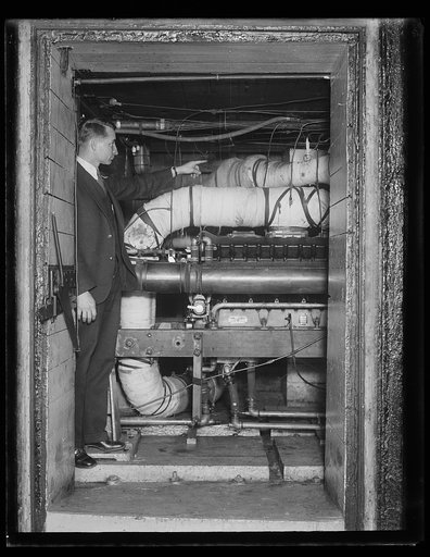 Tests motors by synthetic cold. C.D. Bruce, of the automotive power plant section of the Bureau of Standards, makes a test of airplane motors to show how much coldness they can stand due to high altitude. The testing pipes get as cold as 53 degrees below zero. 12/30/30