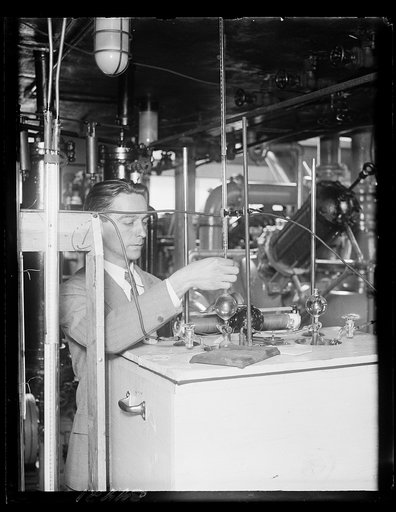 Tests cold effects on airplanes. Donald Brooks, Automotive Engineer of the Bureau of Standards, examining the valves of the apparatus known as the humidifier, which enables Bureau experts to test the effect of cold upon airplanes