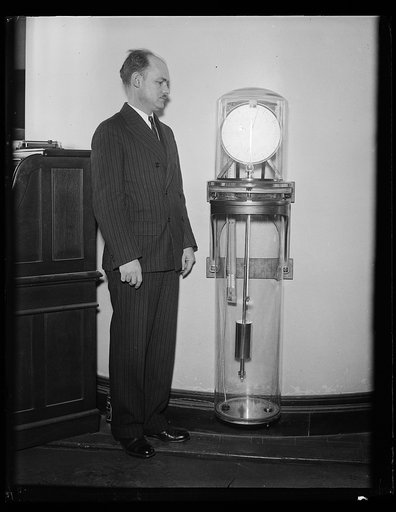 Man with a Riefler pendulum clock, the primary standard for time interval measurments from 1904 to 1929