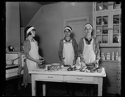 Girl Scouts preparing food in kitchen