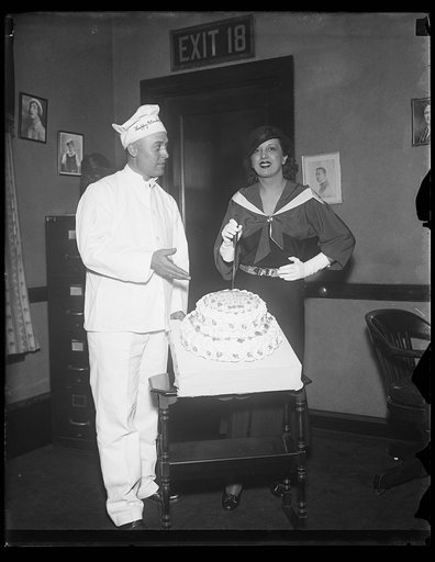 Man dressed as baker and woman with cake