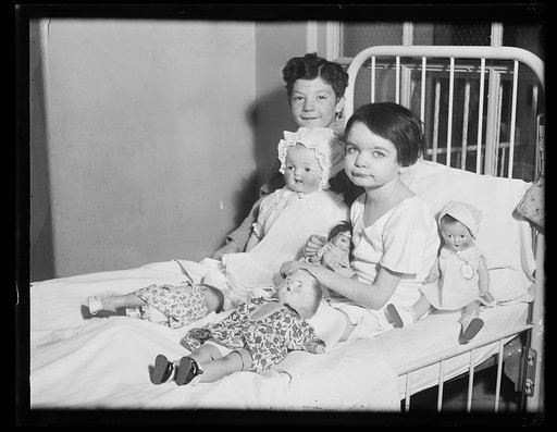 Children in bed with dolls; in hospital?