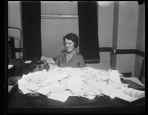 Woman at desk with pile of mail