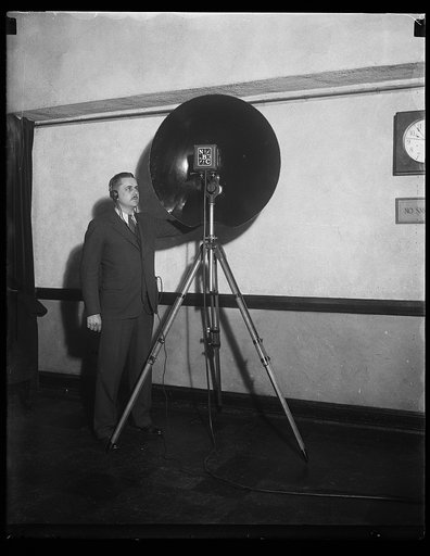 Man with an NBC parabolic dish microphone used for recording distant sounds
