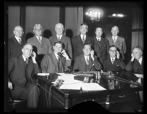 Group, back row: Robert P. Lamont, 3rd from left, Henry C. Wallace, 4th from left; front: Ray Wilbur holding telephone