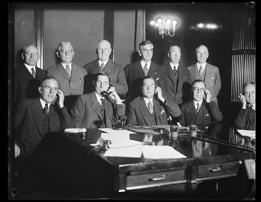 Group, back row: Robert P. Lamont, 3rd from left; front: Ray Wilbur holding telephone