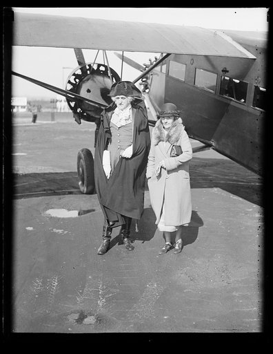 Man dressed as George Washington and woman at airplane